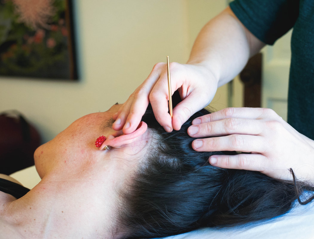 Image shows acupuncturist using teishin on patient's scalp.